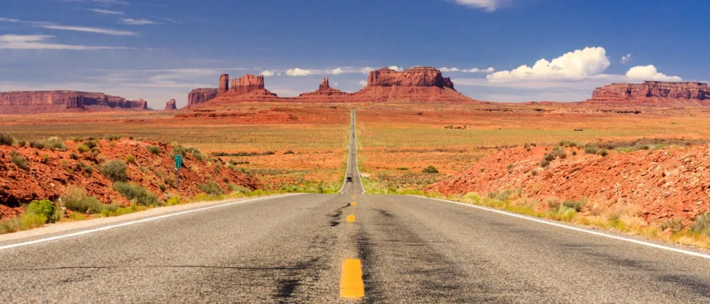 The red sandstone buttes and mesas of Monument Valley under a clear blue sky.