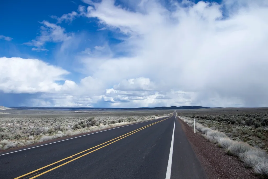 Highway 20 stretching through diverse American landscapes, with rolling hills and open roads.