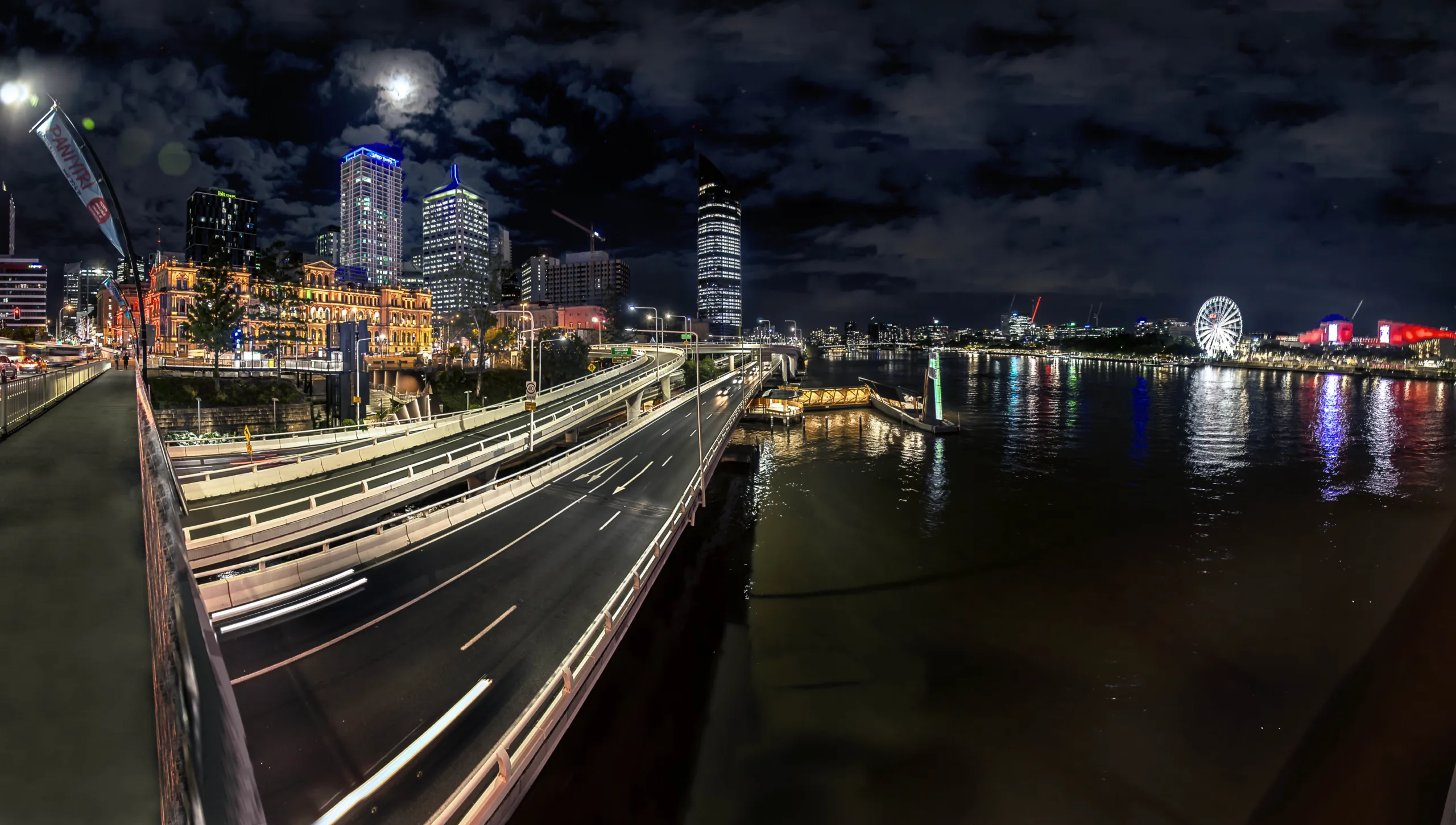 Brisbane River at night with city lights reflecting on the water.