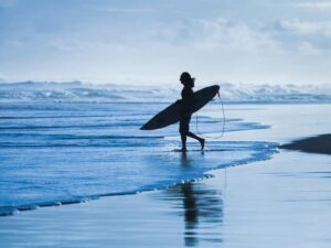 Surfer walking in the water at Byron Bay