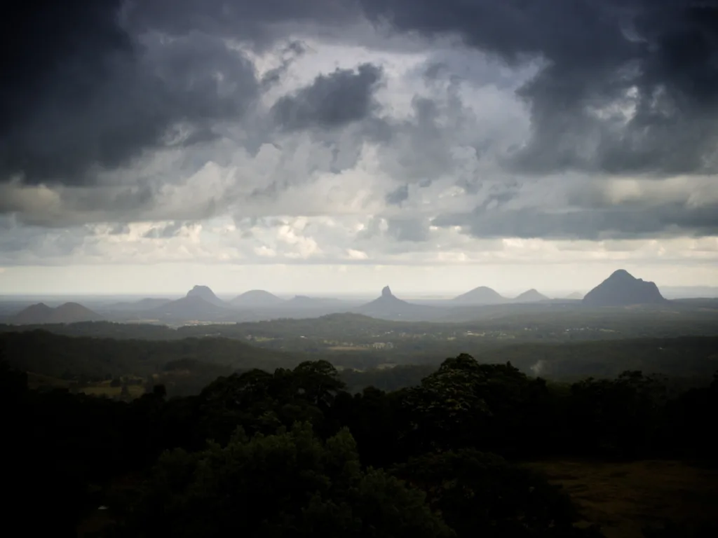 The Glass House Mountains with lush greenery in the foreground.