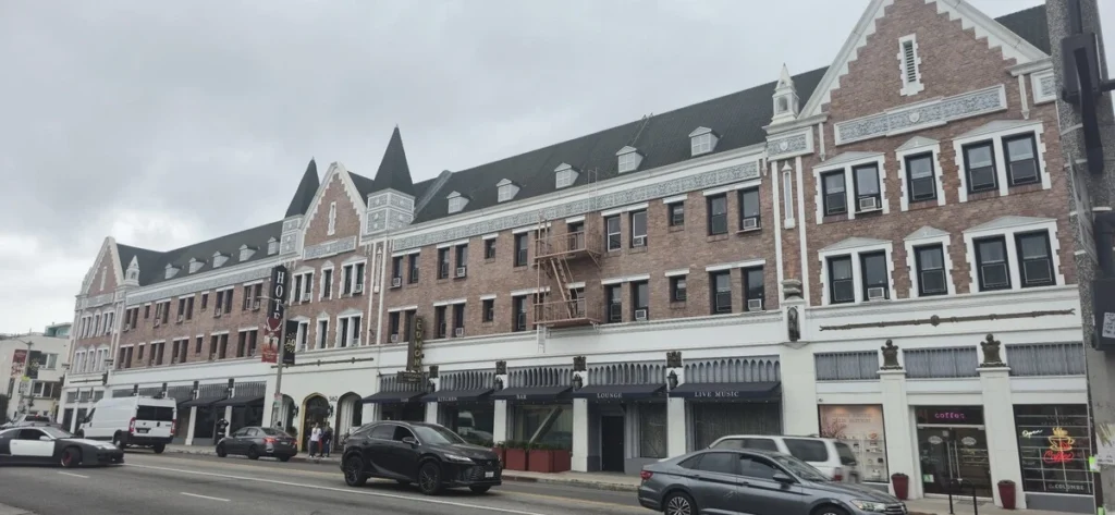 Historic Hollywood Hotel exterior on Hollywood Boulevard with classic brick facade and street traffic in front. Iconic Los Angeles hotel known for its central location near major attractions.
