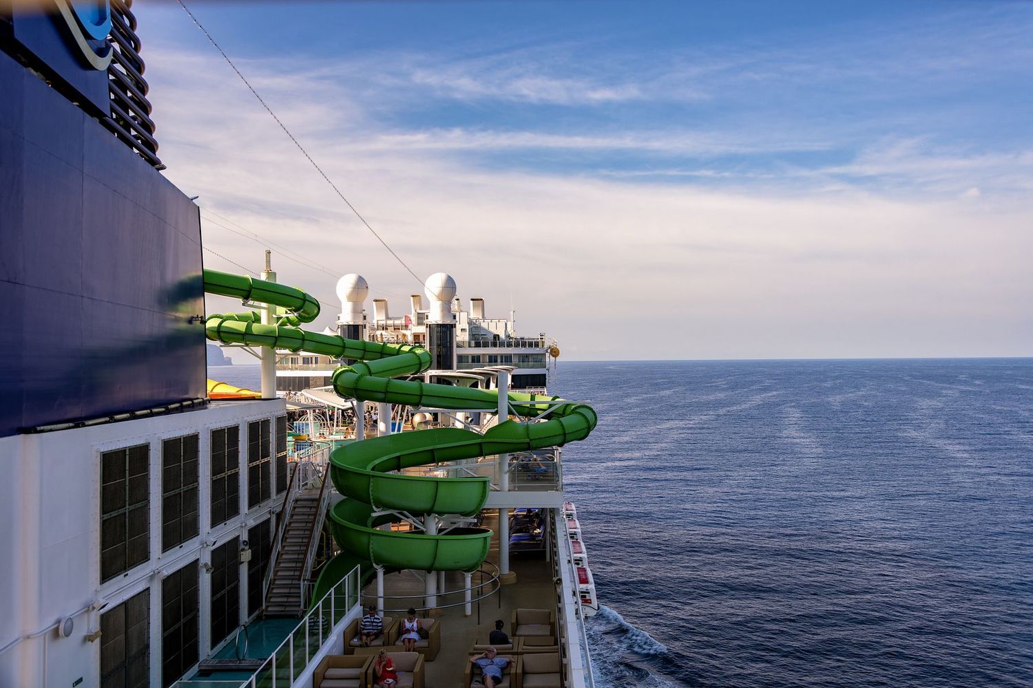 Spiral waterslide and pool deck on a large family cruise ship at sea