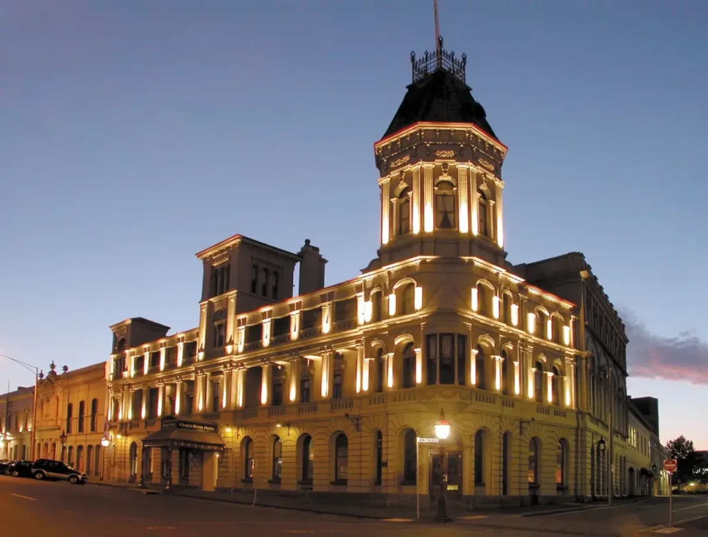 Craigs Royal Hotel in Ballarat glowing with warm exterior lights beneath the evening sky. The grand historic building offers a memorable heritage stay for a Ballarat family holiday.