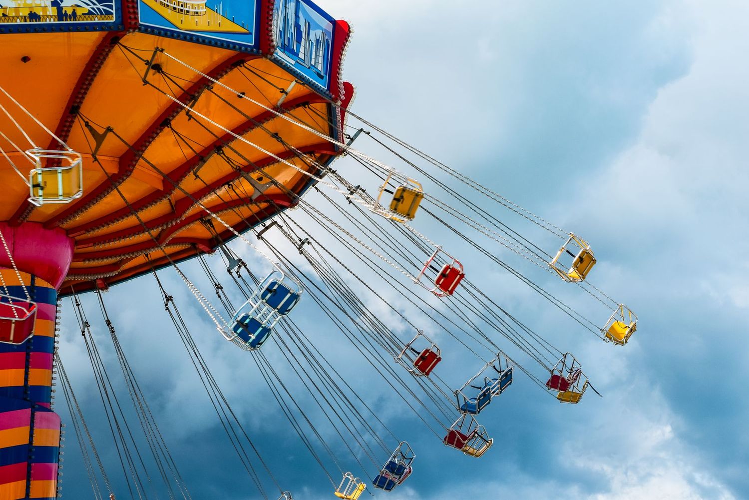 Colourful swing-chair carousel ride against the sky at a theme park