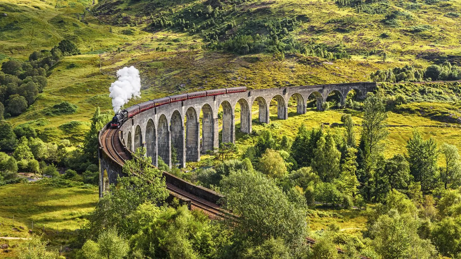 Steam train crossing the Glenfinnan Viaduct in Scotland